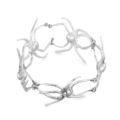 A silver bracelet featuring intricate spider head designs, crafted by artist Sue Webster.