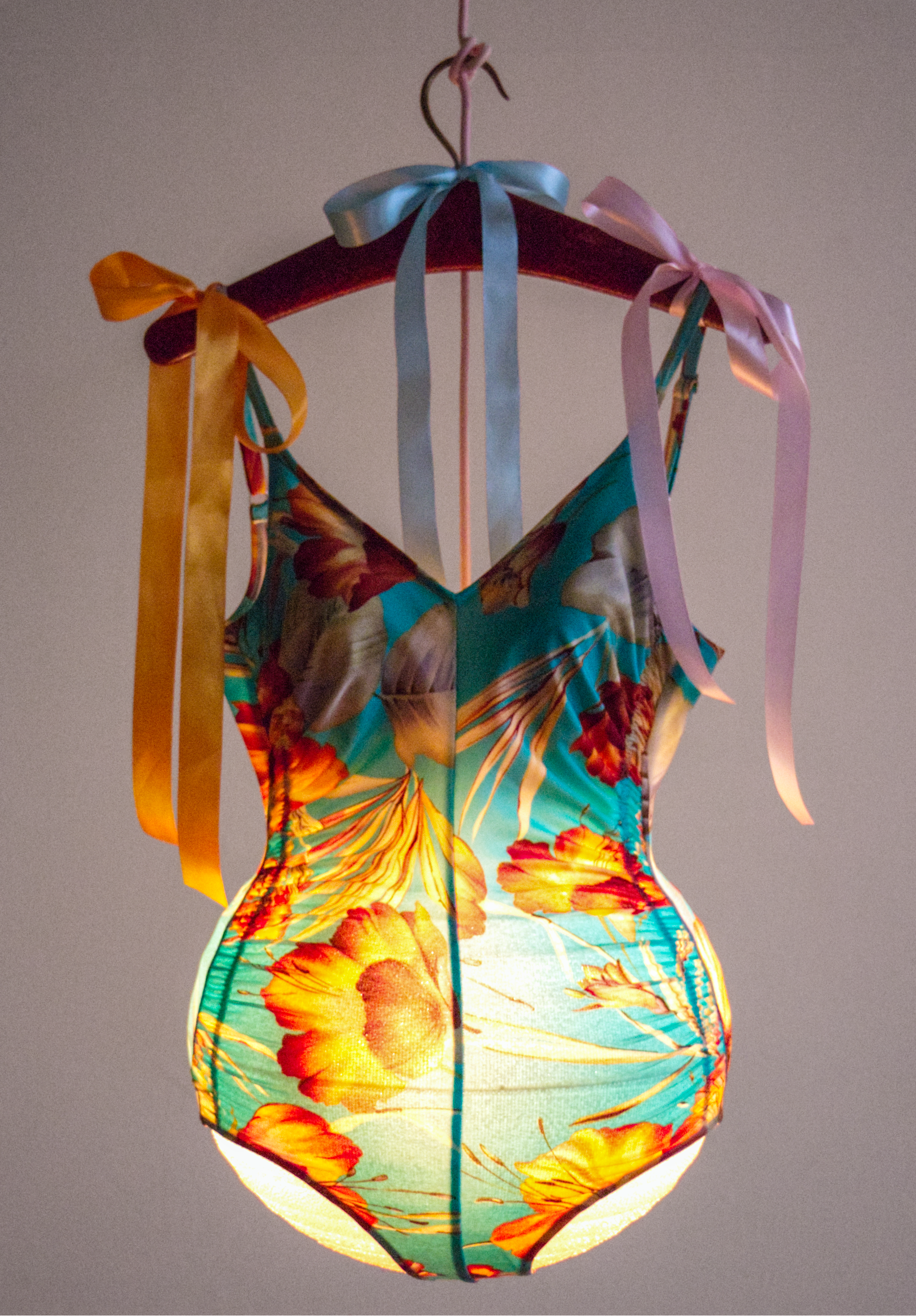 The Wick - Anouk, The Enlightened Granddaughter (orange turquoise) 
2021
Swimsuit, round metal lamp shade skeleton, frosted glass spherical lamp, fabric cable and plug, clothes hanger, ribbons
80 x 42 x 37 cm / 31 1/2 x 16 1/2 x 14 5/8 inches
© Pipilotti Rist
Courtesy the artist and Hauser & Wirth
Photo: Atelier Rist
