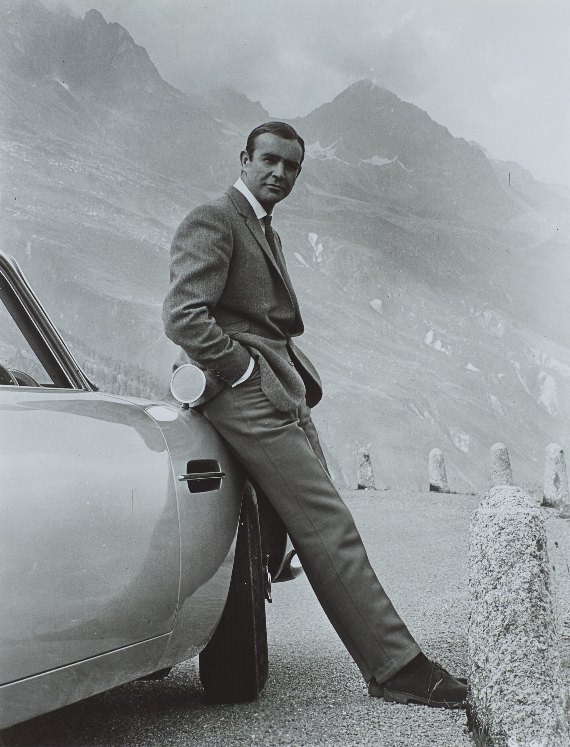 The Wick - Sean Connery with Aston Martin DB5 during the filming of Goldfinger, Furka Pass (estimate £300 - £500)