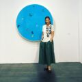 Julia Baumhoff Zaouk, Gallery Director, poses in front of a striking blue circle, symbolizing innovation in contemporary art.