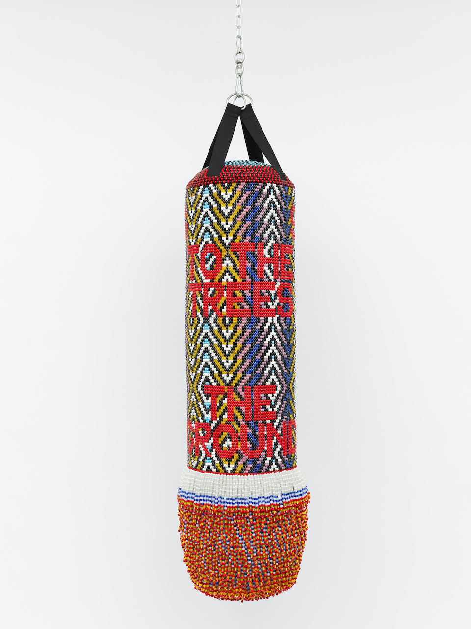 The Wick - Jeffrey Gibson, 'SPEAKING TO THE TREES AND KISSING THE GROUND', 2023. Found punching bag, expanding foam, acrylic felt, glass beads and artificial sinew, 167.6 x 43.2 x 43.2cm (66 x 17 x 17in). Copyright Jeffrey Gibson. Courtesy the artist and Stephen Friedman Gallery, London and New York. Photo by Max Yawney.