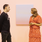 Brunette man in black clothing, Tim A Shaw founder of Hospital Rooms, and brunette woman in red dress, founder of The Wick Katy Wickremesinghe, standing next to each other speaking