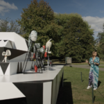 Two women standing in the distance in front of a white multi-dimensional sculpture by İnci Eviner at Frieze Sculpture in Regent's Park.