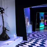 A room featuring black and white walls and floors shows some of Tim Burtons sculptures and art.