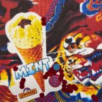 A piece of art by Chila Kumari Singh Burman depicting two tigers heads, an ice cream cone and various other shapes in red, blue, and yellow hues.