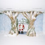 Christmas artwork of Santa Claus between two trees