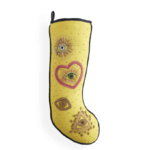 Yellow stocking by Jonathan Adler with bejewelled details, including heart, eyes, and triangle.