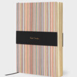 Notebook by Paul Smith with rainbow colourful stripes, which are Paul Smith's signature stripes on a white background.