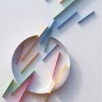 A sculpture on a wall with a circle and rainbow lines