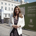 A woman wearing a white blazer and dress