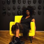 Black woman sitting a yellow chair