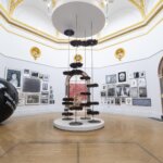 A round room with a sculpture in the centre with artwork on the walls