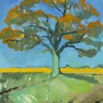 A green tree with orange leaves in a field