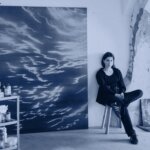 A woman sitting in front of an artwork