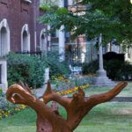 A sculpture of a brown piece of bark in a garden