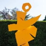 A yellow sculpture in a garden