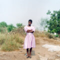 A woman wearing a pink dress standing outside