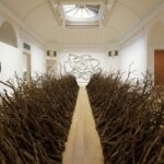 A gallery room with twigs lining either side
