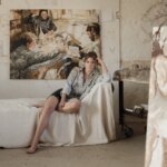 A woman sat on a sofa in an artist studio