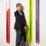 A woman standing in front an artwork