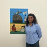 A woman standing in front of a painting