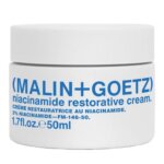 A white cream pot with blue writing