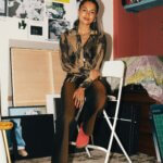 A woman sat on a chair in a studio
