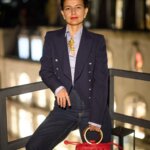 A woman wearing a blue suit standing on a balcony
