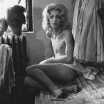 A black and white photo of a person on a bed