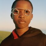 A photograph of a child with straw glasses