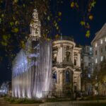 A building draped with silver fabric photographed in the dark