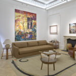 A view of gallery room with furniture and paintings