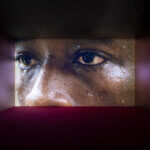 Art video installation of a boy staring into the distance.
