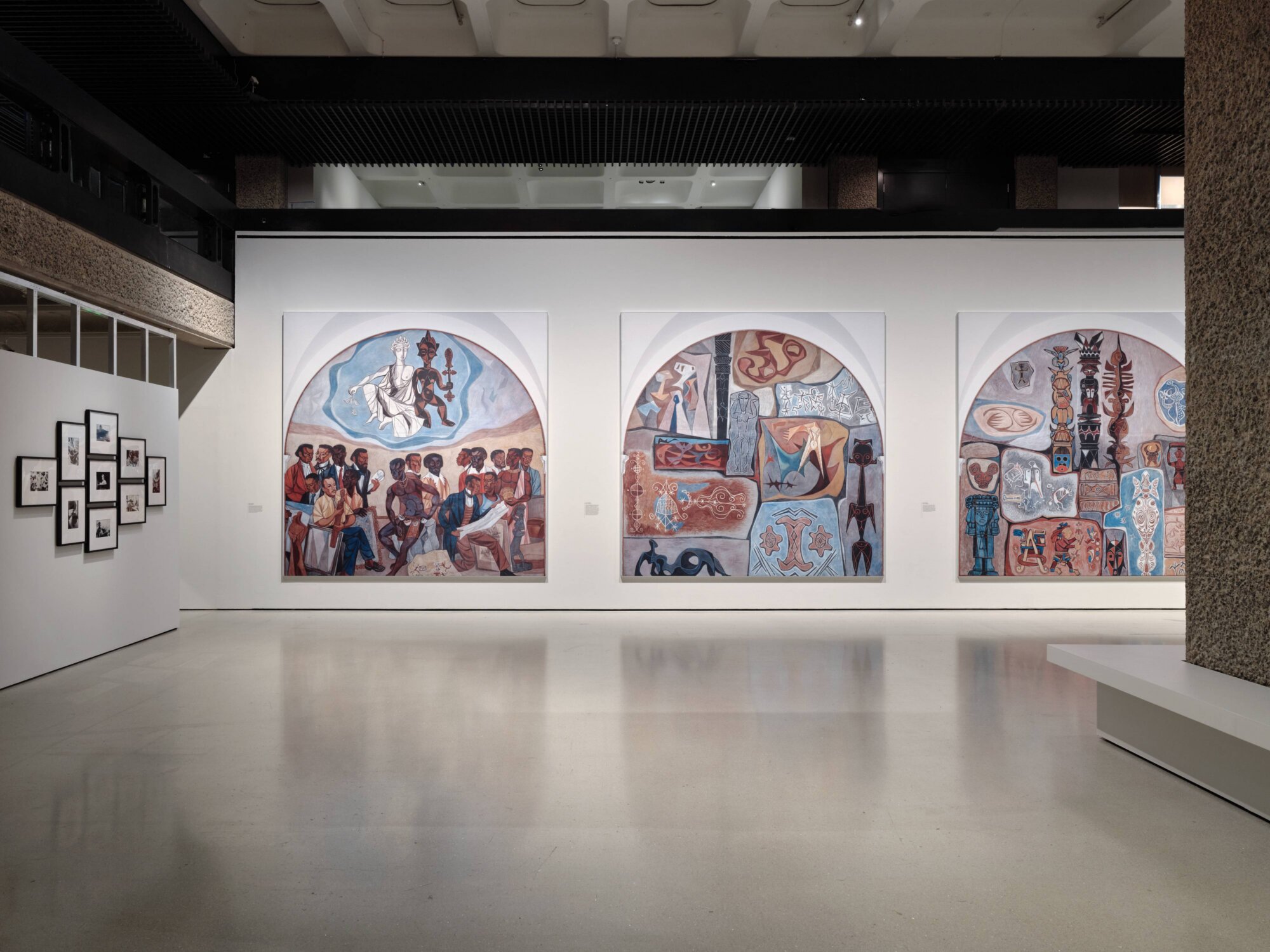 The Wick Culture - Art of the Negro Panels (1952) by Hale
Aspacio Woodruff and Photographs for
Passion: Discourses
on Blackwomen’s Creativity, edited by
Maud Sulter (1984–89) by
Ingrid Pollard. Project a Black Planet: The
Art and Culture of Panafrica, Installation
View, 11 Jun – 6 Sep 2026 © Thomas
Adank/Barbican Art Gallery